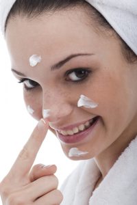 teen putting on skin cream