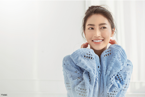 Young woman in a light blue sweater smiling